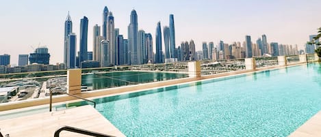 A swimming pool with a city skyline in the background.