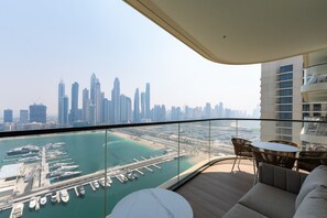 A balcony with a view of a marina and city skyline.