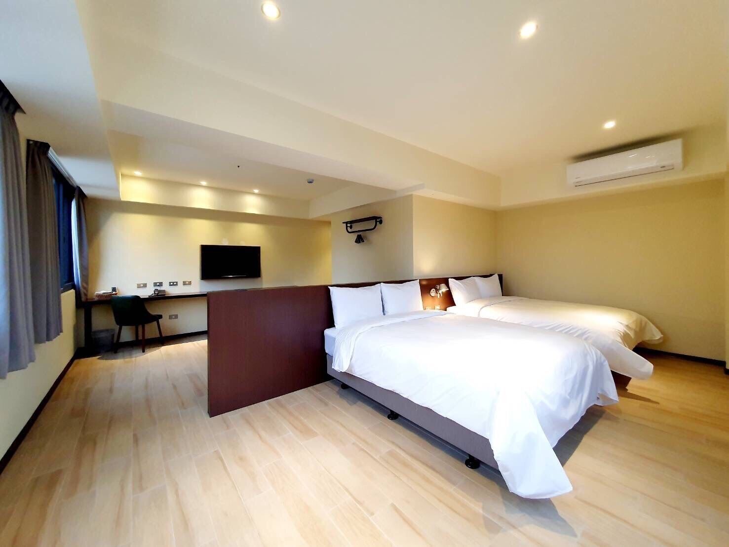 A modern hotel room with a large bed, a desk, and a flat-screen TV.
