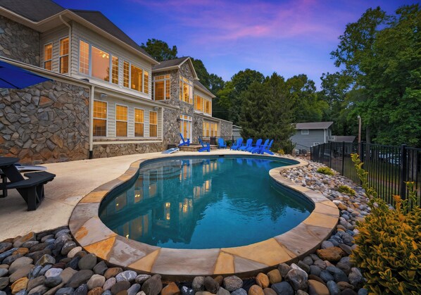 Une maison avec une piscine, des murs en pierre et un espace patio.