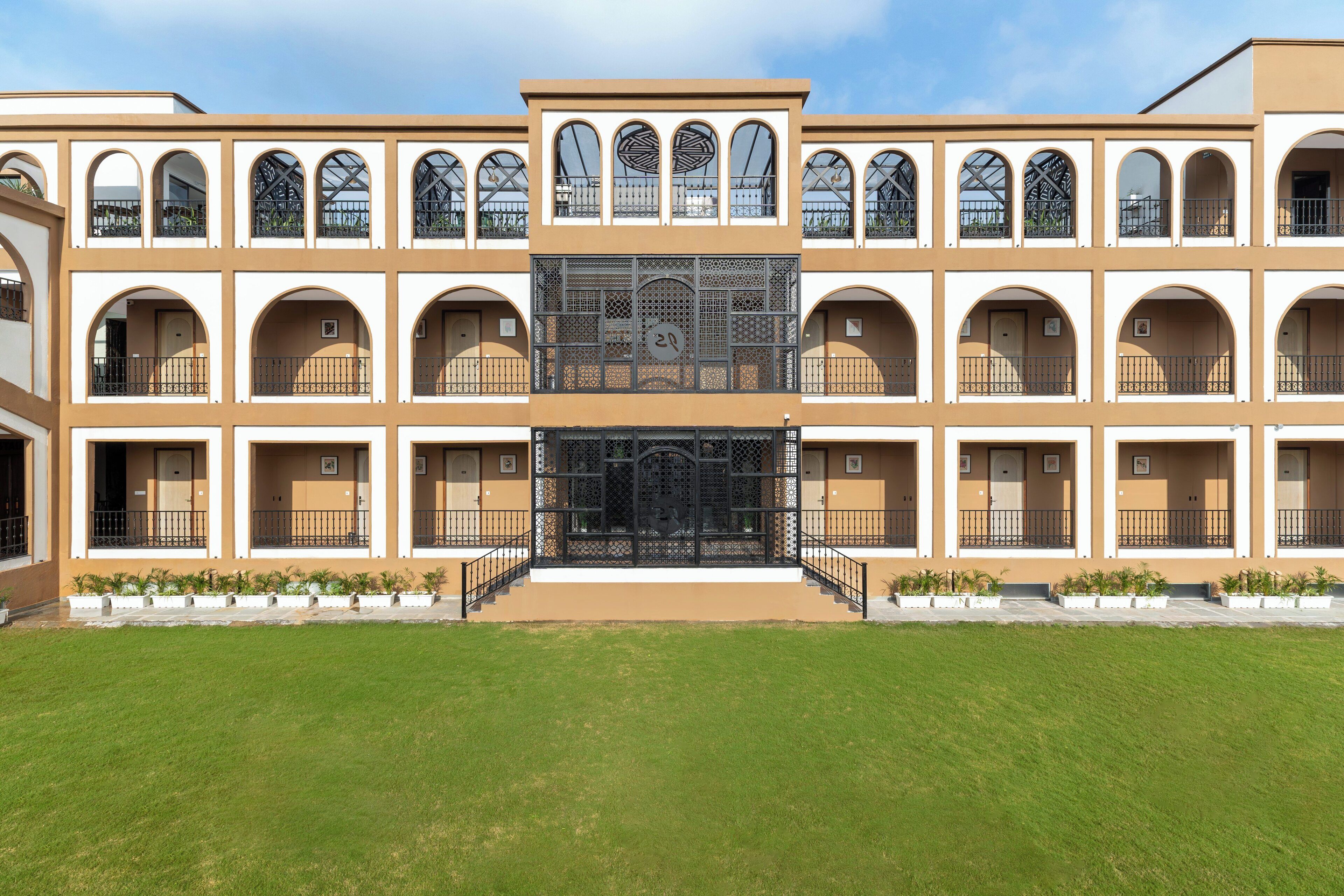 A multi-story building with a central courtyard, featuring a symmetrical facade with arched windows and balconies.