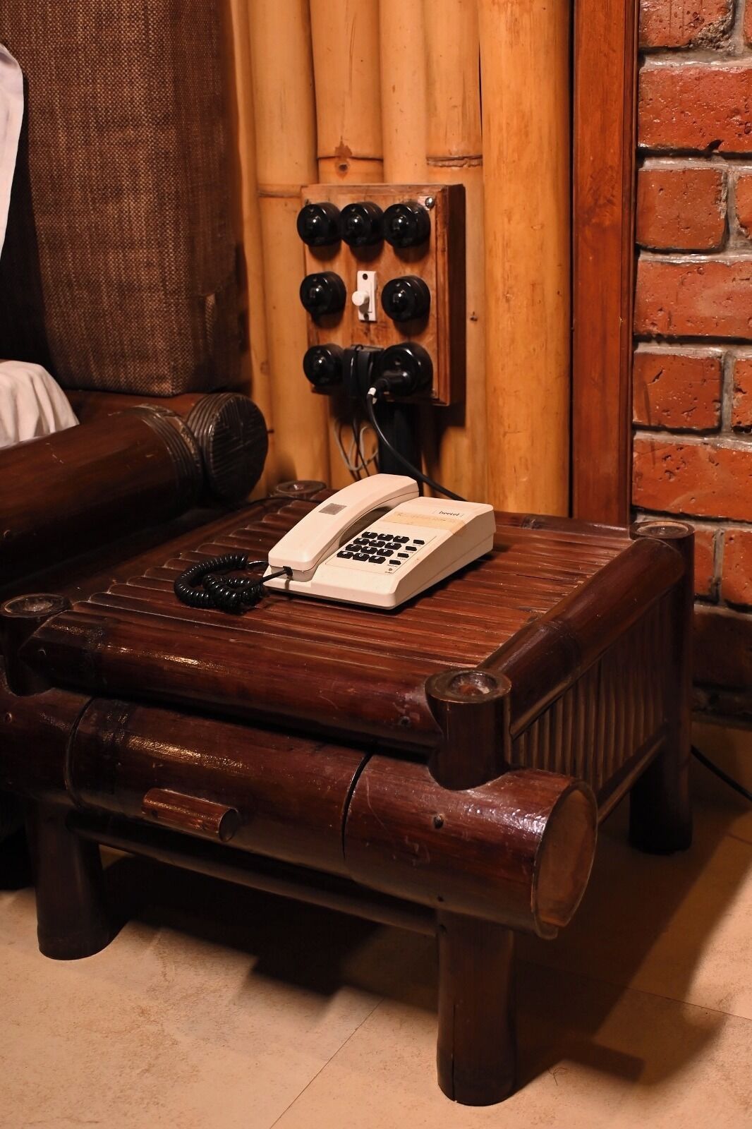 A wooden table with a telephone and a coiled cord.