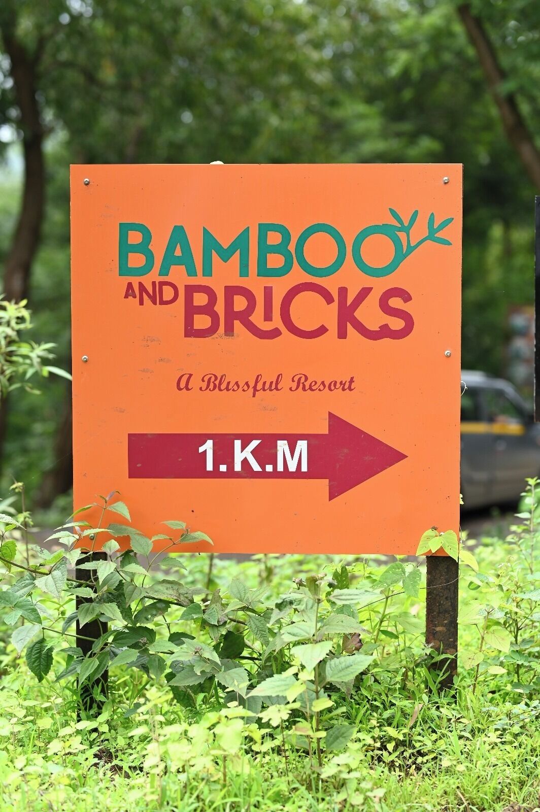 A sign for 'Bamboo and Bricks' with an arrow pointing to the right, indicating the direction to the resort.
