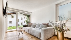 A modern living room with a sofa, a small round table, and a decorative vase.