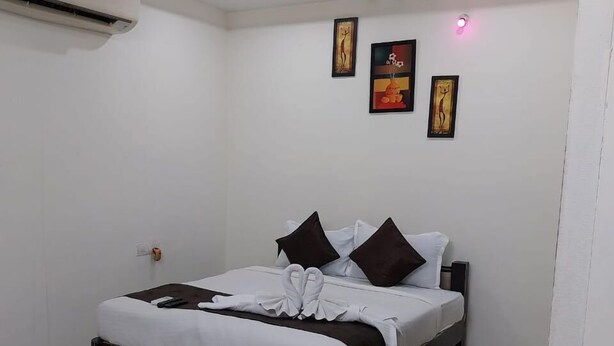 Ein modernes Hotelzimmer mit Bett, Deckenventilator und Bildern an den Wänden.