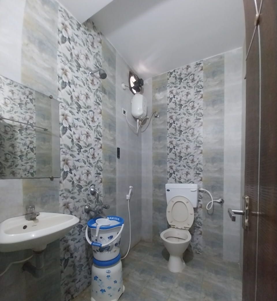 Un baño con inodoro, lavamanos y dispensador de agua.