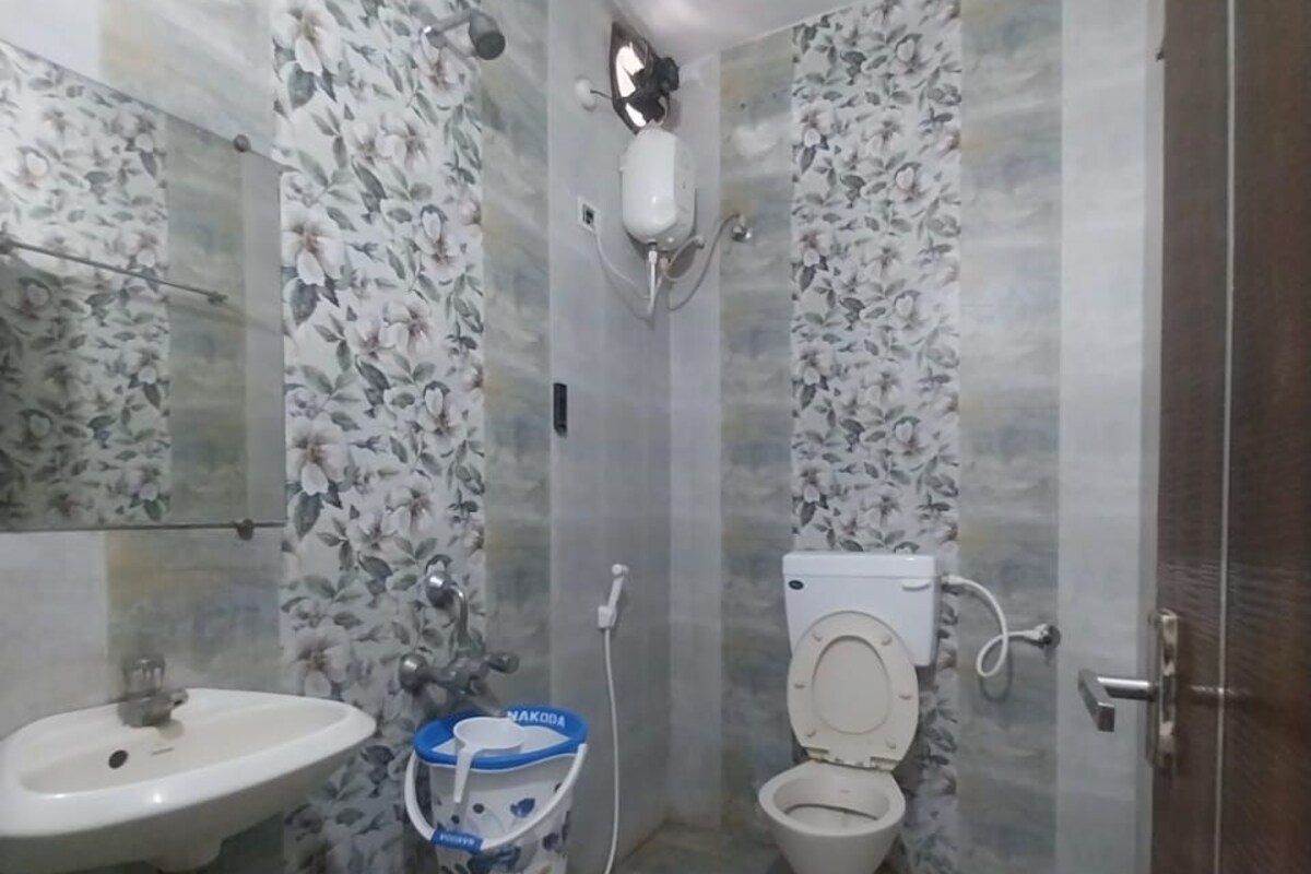 Un baño con inodoro, lavamanos y dispensador de agua.