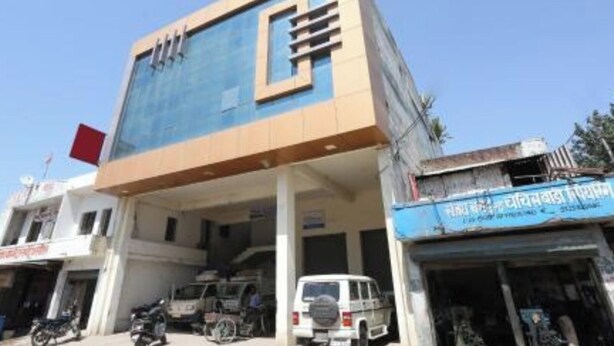 A multi-story building with a prominent blue and beige facade, featuring a large logo on the front. - Hotel S K Palace (Lucknow)