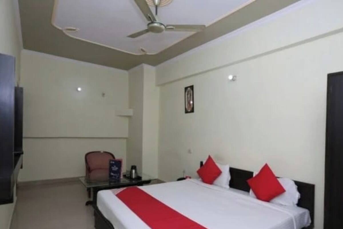 Habitación de hotel con una cama grande, un escritorio, una silla y un ventilador de techo.