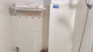 A small bathroom with a toilet, a sink, and a shower. - A10 Thuy Hoa Hotel LC  - by BAY LUXURY (Lao Cai)