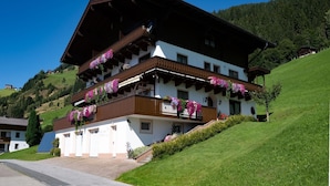 A two-story chalet with a sloped roof, wooden balconies, and flower boxes. - Farmhouse in Hollersbach with Mountain Views (Hollersbach im Pinzgau)