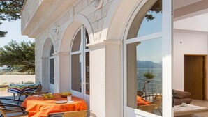 A dining area with a table set for two, overlooking a scenic view. - Apartments Bezek - Studio Apartment with Sea View (Trstenik)