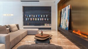 Un salon moderne avec un canapé, une table basse, une cheminée et une bibliothèque.