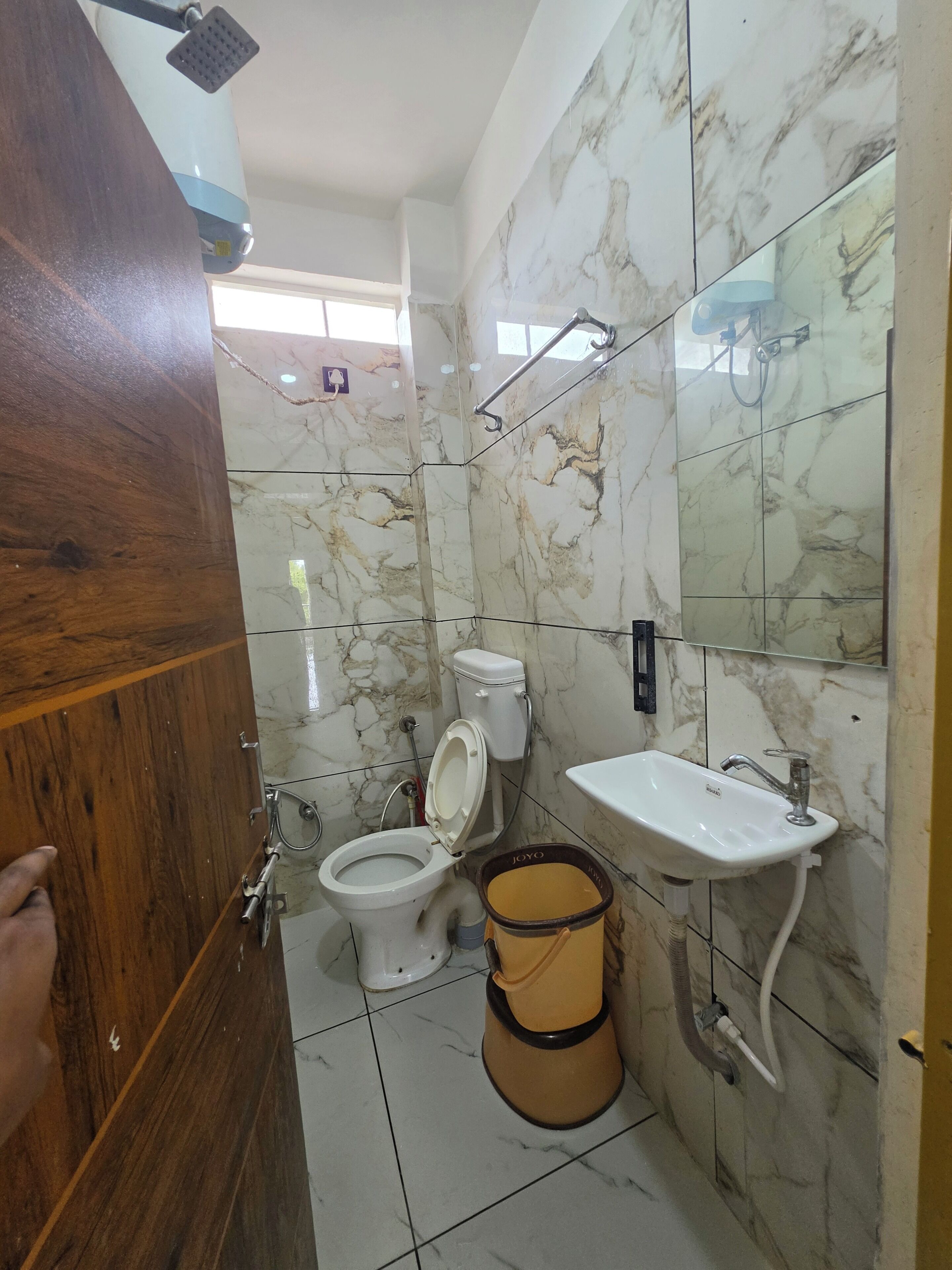 A bathroom with a toilet, sink, and shower.