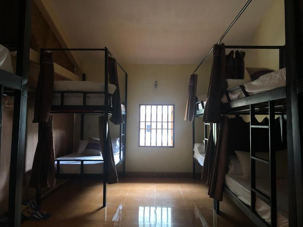 Una stanza del dormitorio con letti a castello, una finestra e un pavimento piastrellato.