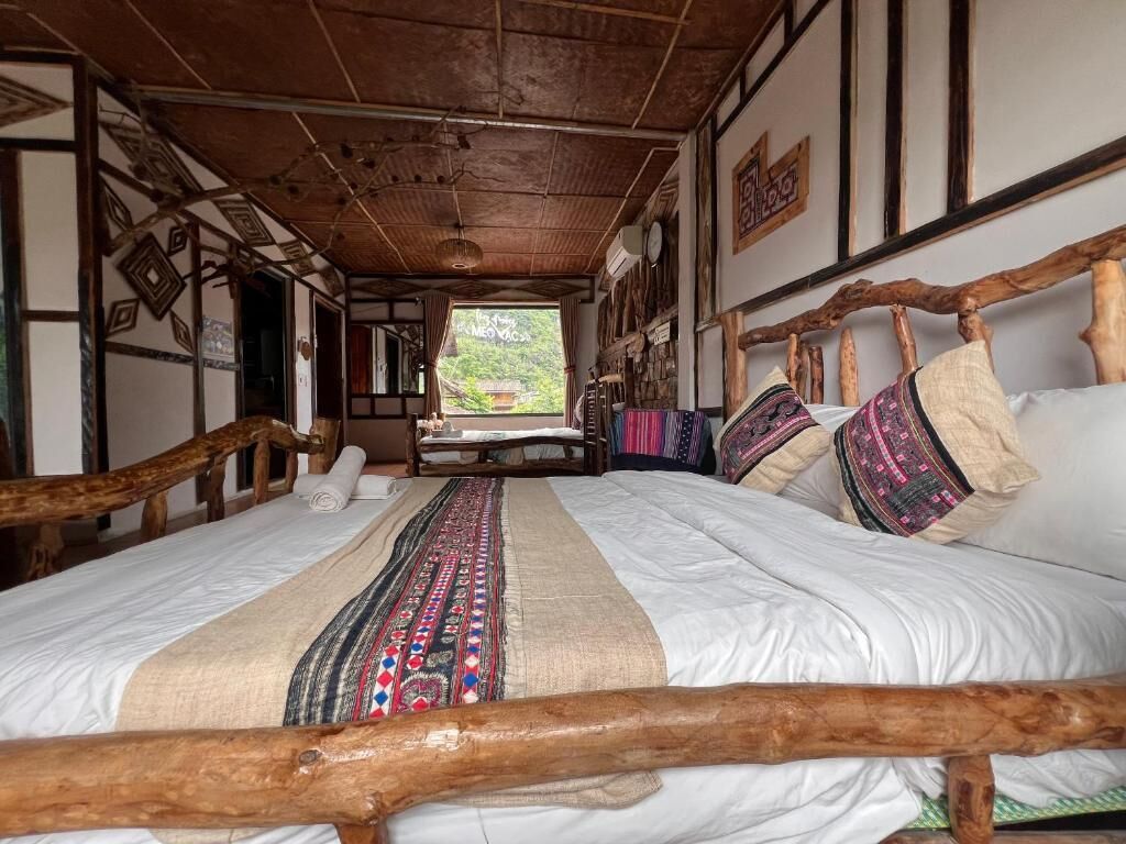 A traditional room with a bed, wooden headboard, and a view of the outdoors.