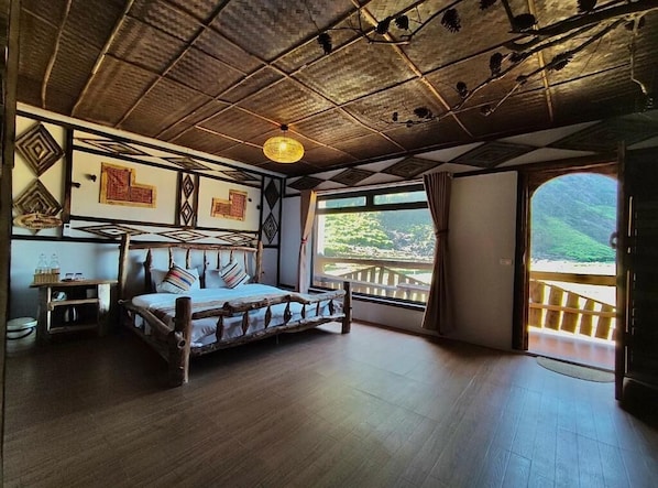 A rustic room with a wooden bed, a hanging light fixture, and a view of a balcony with a wooden railing. - O'Chau Meo Vac Homestay (Meo Vac)