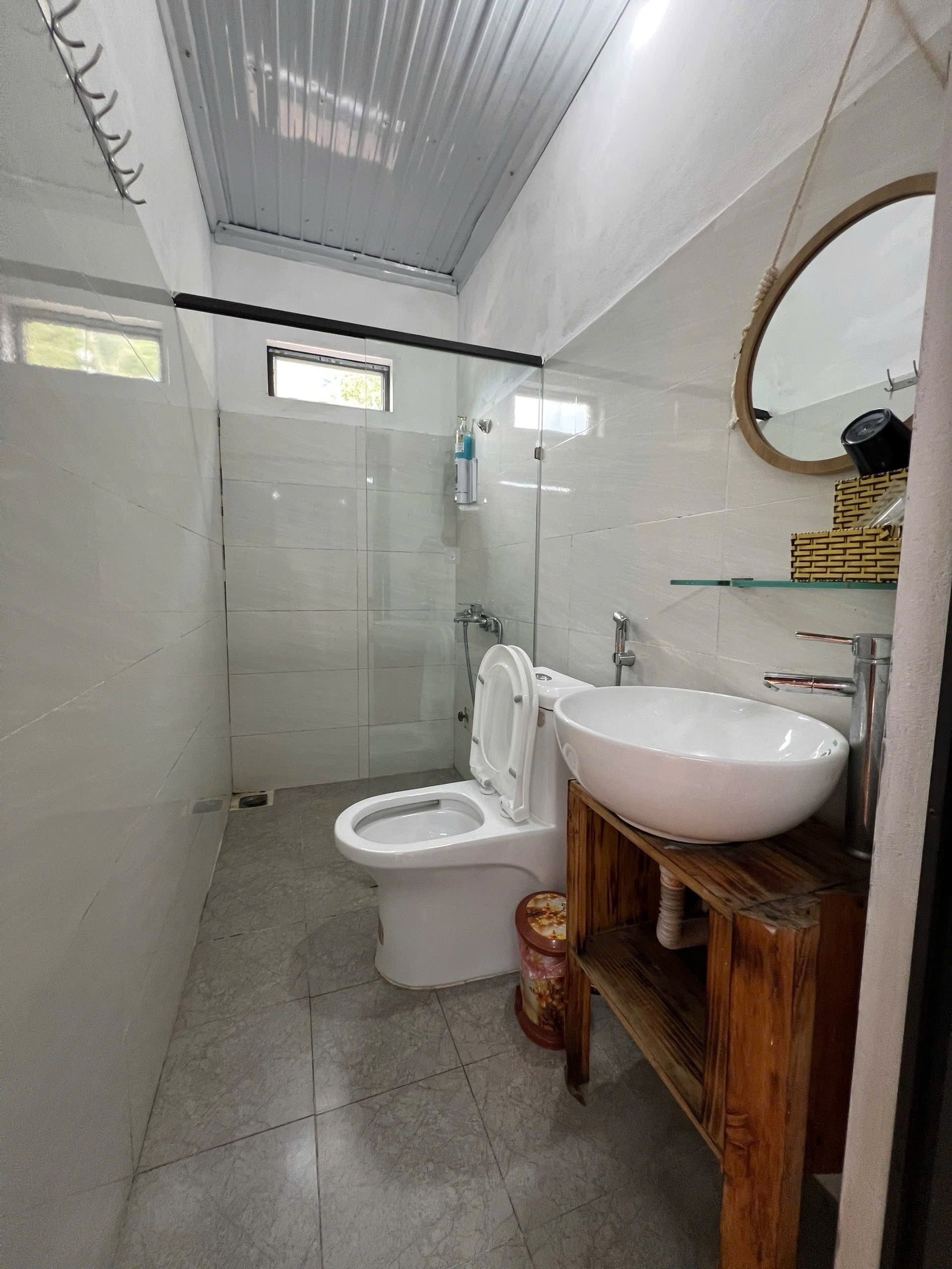 A bathroom with a toilet, sink, and shower.