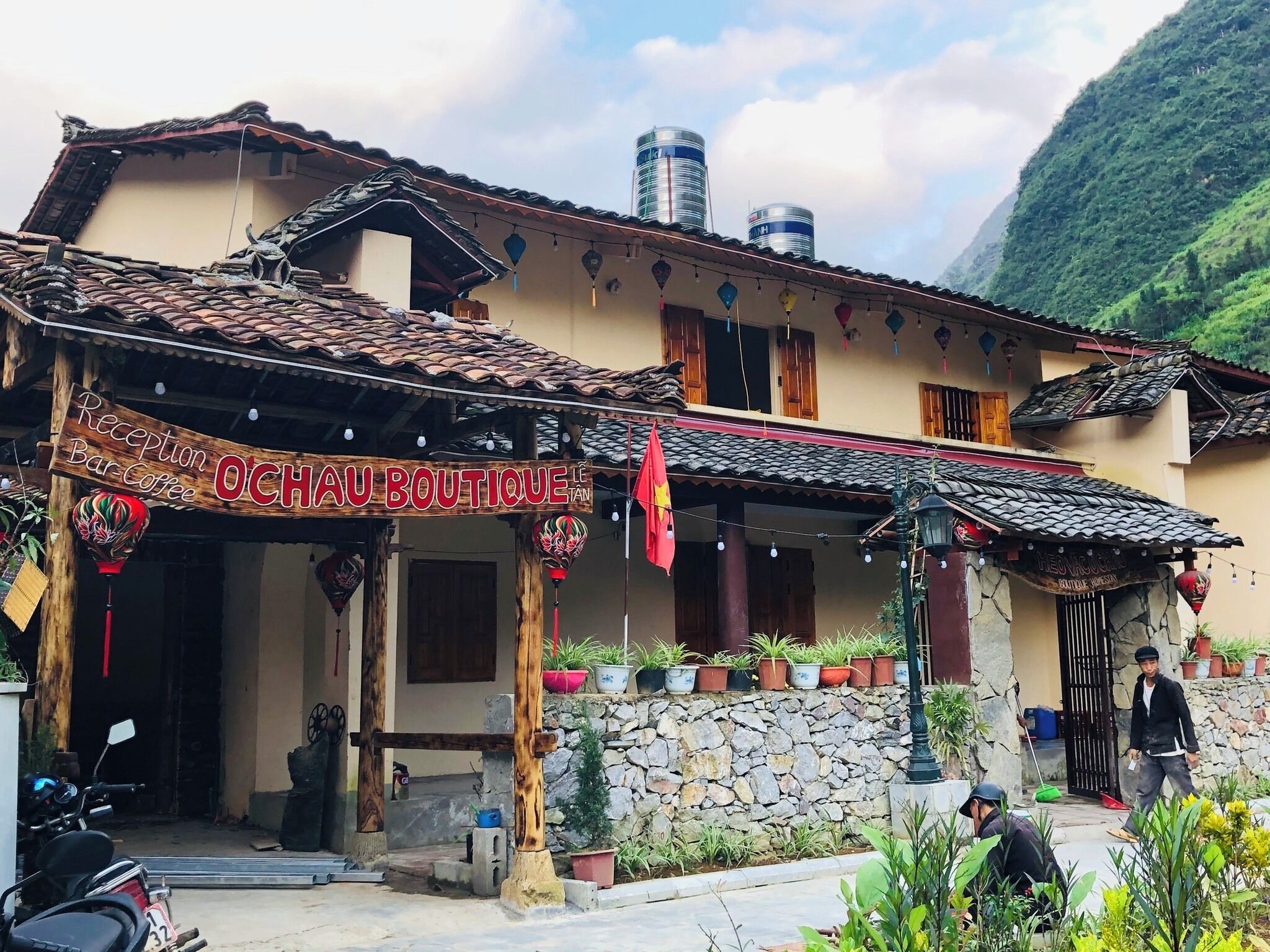 Um edifício tradicional com uma placa que diz 'Reception Bar Coffee OCHAU BOUTIQUE'.