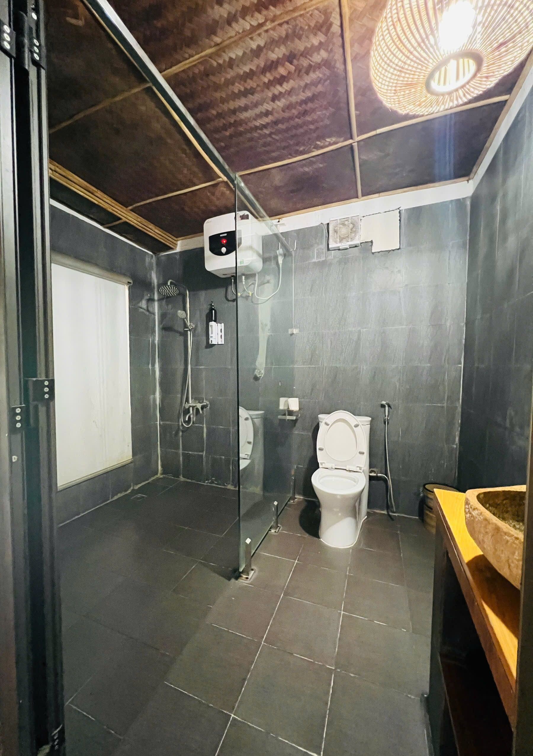A bathroom with a shower, toilet, and a sink.