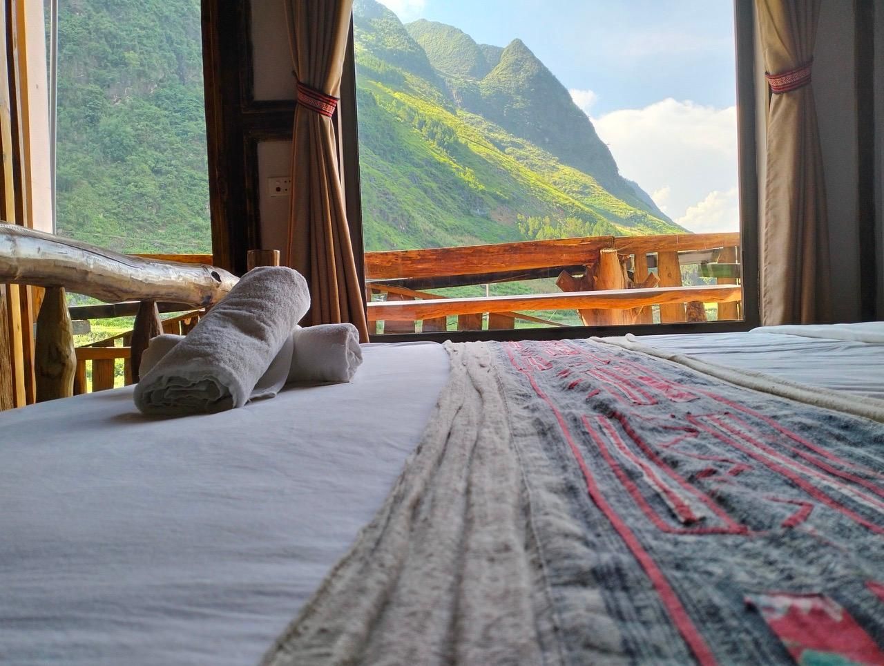 Una cama con vista a un paisaje montañoso a través de una ventana.