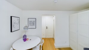 Une pièce au décor minimaliste, avec une table blanche, des chaises et une citation encadrée accrochée au mur.