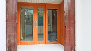A wooden door with glass panels and a small porch area. - Vrrinda By GRB (Varanasi)