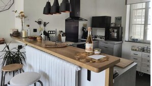 A modern kitchen with a central island, pendant lighting, and a black range hood. - Cosy, country-style 3* gîte in the heart of Picardy's heritage, sleeps 5 (Mesbrecourt-Richecourt)