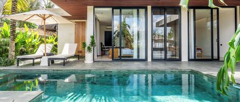 Una piscina al aire libre, sombrillas, tumbonas