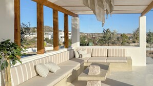 Un área de estar moderna al aire libre con vistas a un pueblo en la ladera.