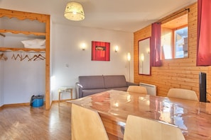 Ambiente interno in legno con un divano, un tavolo e un attaccapanni.