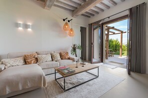Un salon moderne avec un canapé, une table basse et des luminaires suspendus.