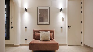 A bedroom with a bed, two wall-mounted lights, a framed picture, and a door. - Luxurious studio in the heart of Madrid - ST 3 (Madrid)