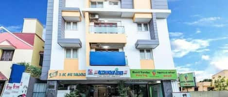 A multi-story hotel with balconies, a visible restaurant, and a sign for Hotel Varsha.