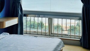 A bedroom with a large window offering a view of the sea. - Oasky Apartment Vung Tau (Ho Chi Minh City)