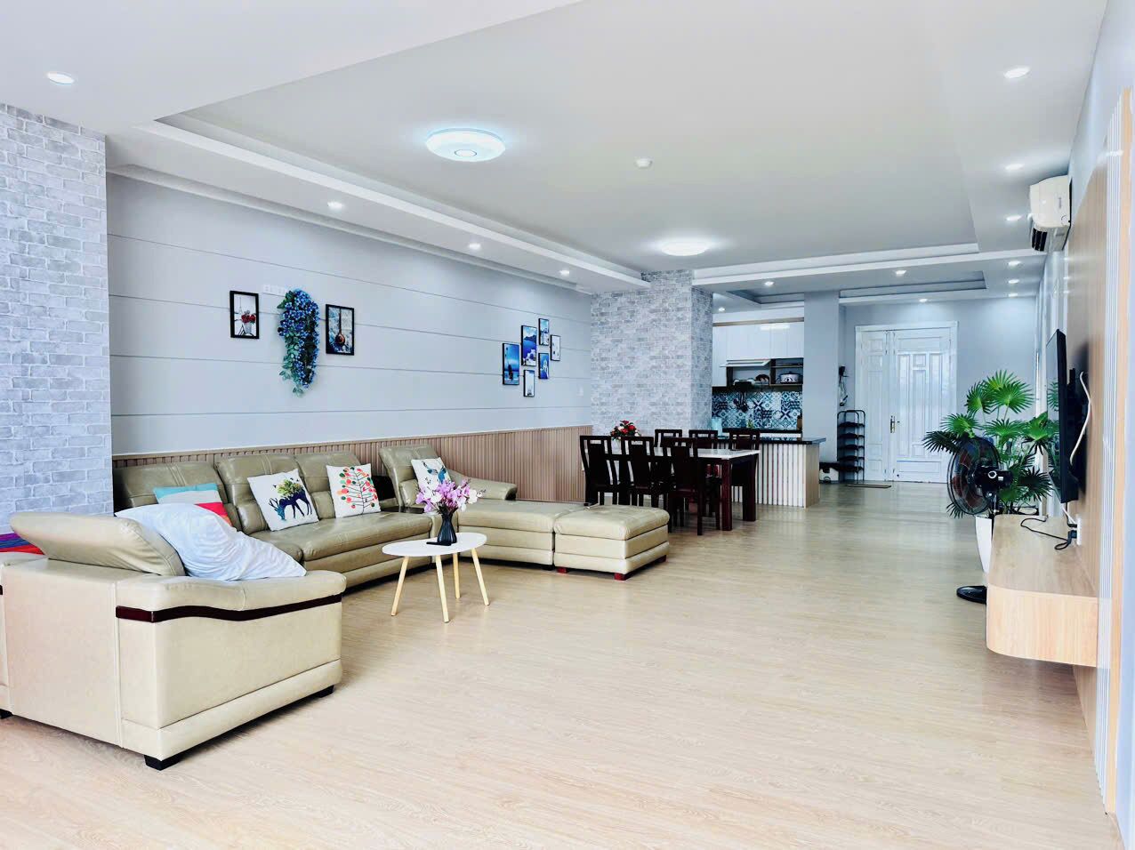 A modern living room with a sofa set, a coffee table, and a dining area with chairs and a table.