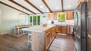 Una cocina moderna con armarios de madera, una isla grande y un refrigerador de acero inoxidable.