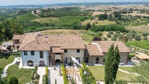A large, two-story house with a tiled roof, surrounded by lush greenery and vineyards. - Correggiolo Romantic Apartment Pool Montaione Toscana (Montaione)