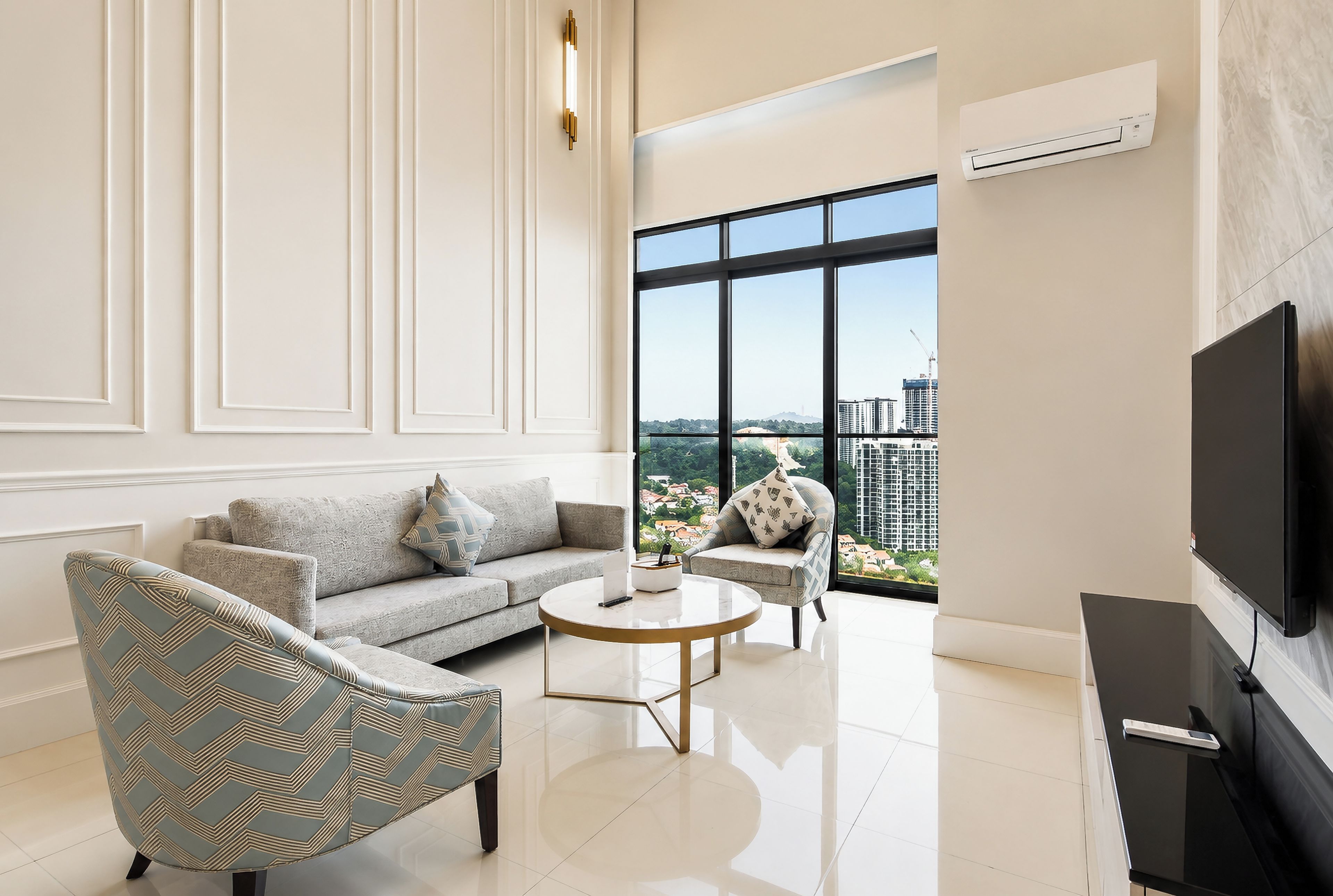 Una sala moderna con sofá, sillón, mesa de centro y televisor.