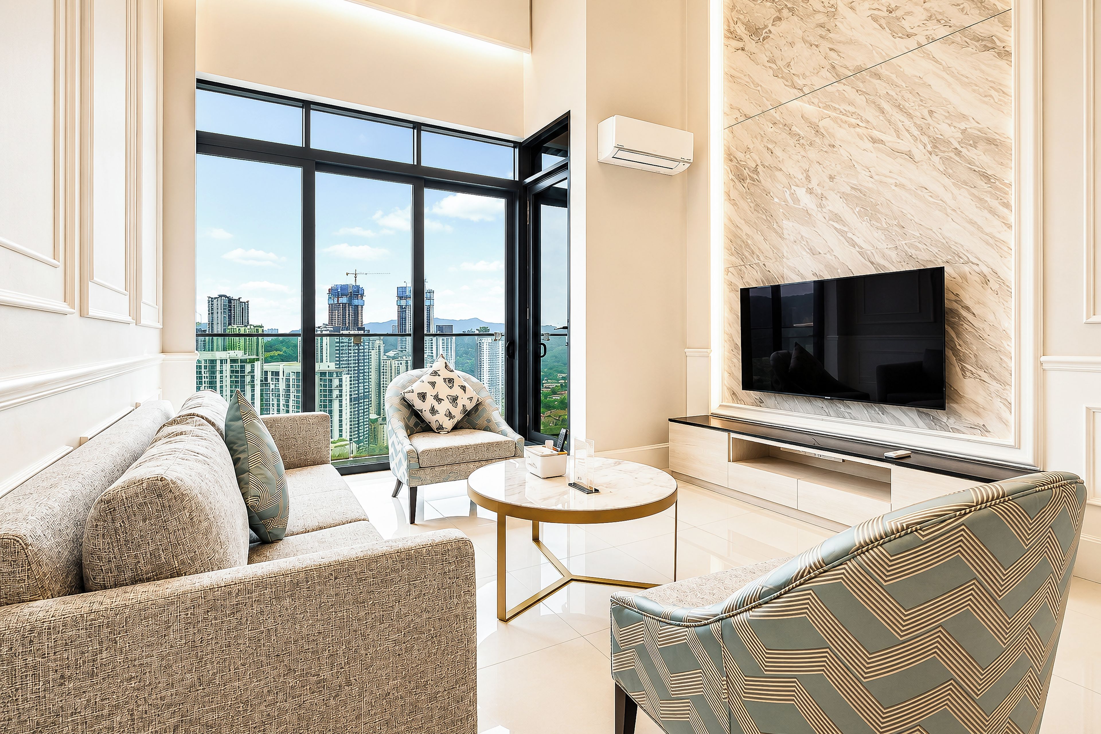 A modern living room with a large TV, comfortable seating, and a view of the cityscape.