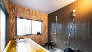Een sparuimte met een groot bad, een douche en een raam voor natuurlijk licht.