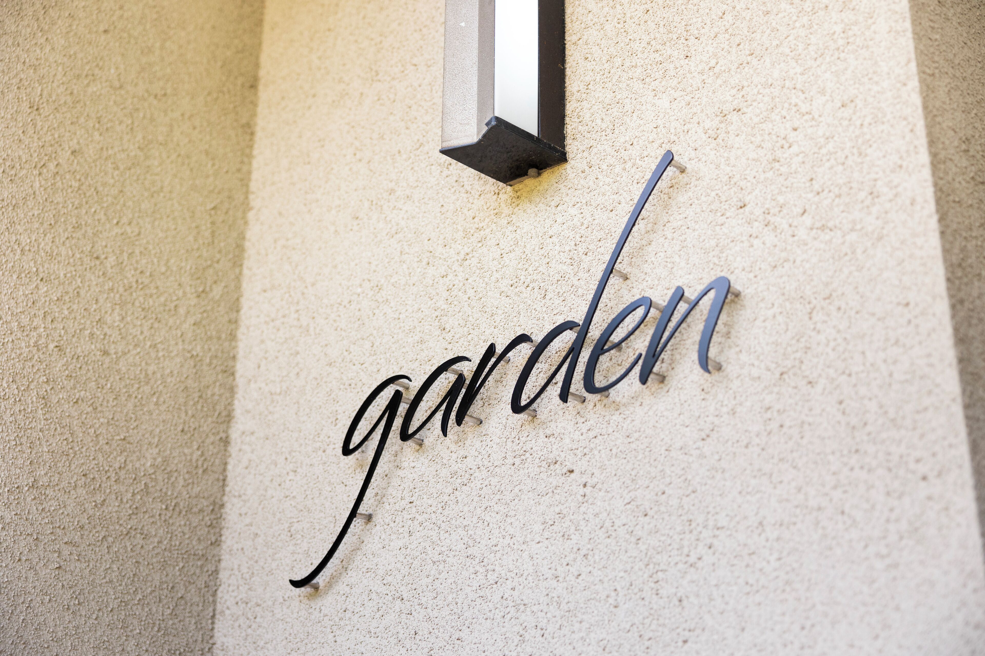 Una pared con textura y la palabra 'garden' en letras negras y azules.