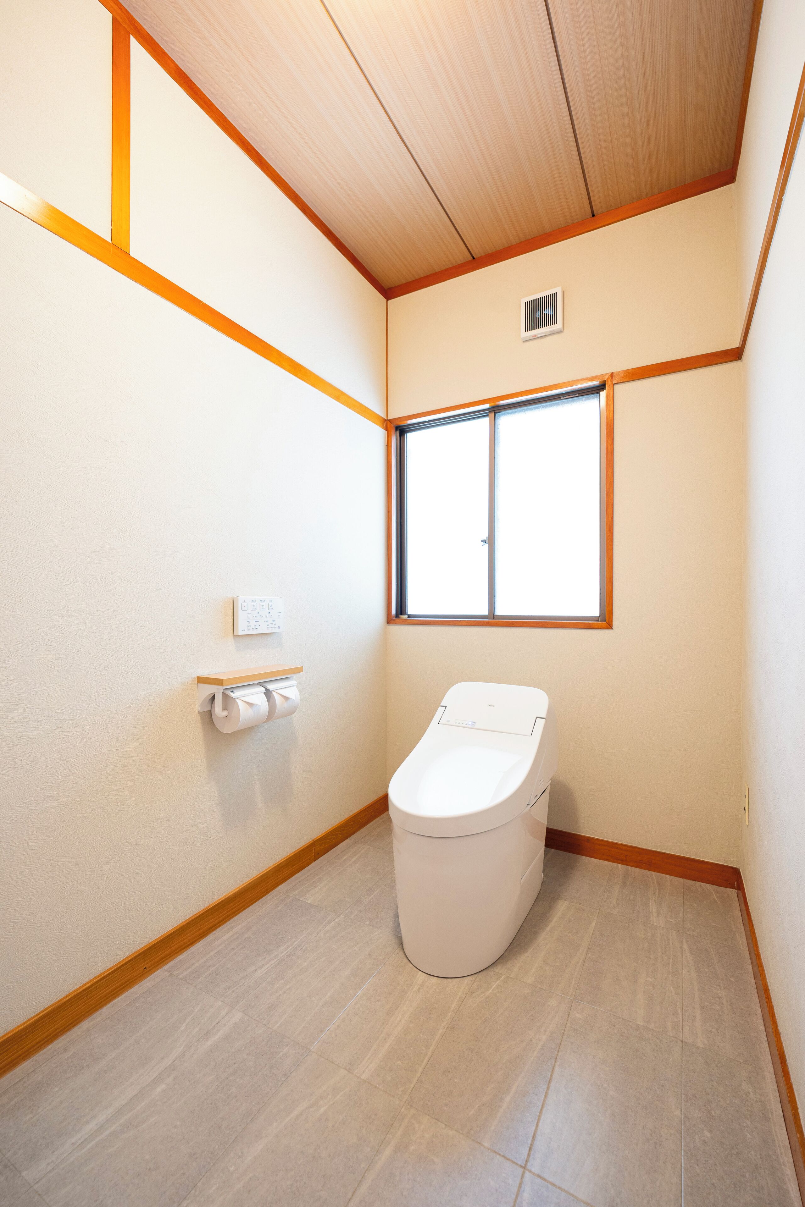 Ein kleines, sauberes Badezimmer mit Toilette, Fenster und Wandheizung.