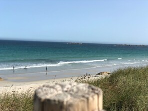 A beach with a wooden post in the foreground and a clear view of the ocean. - Gite Tiarmein 2bedrooms with swimming pool 2 steps from the sea (Guissény)