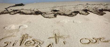 A beach with sand writing that reads "C'est toi avec Moi".