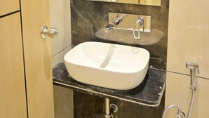 Un baño con un lavamanos blanco, un espejo y una ducha.