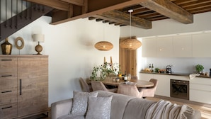 Una cocina moderna con armarios de madera, un comedor con mesa y sillas, y una sala de estar acogedora con un sofá.