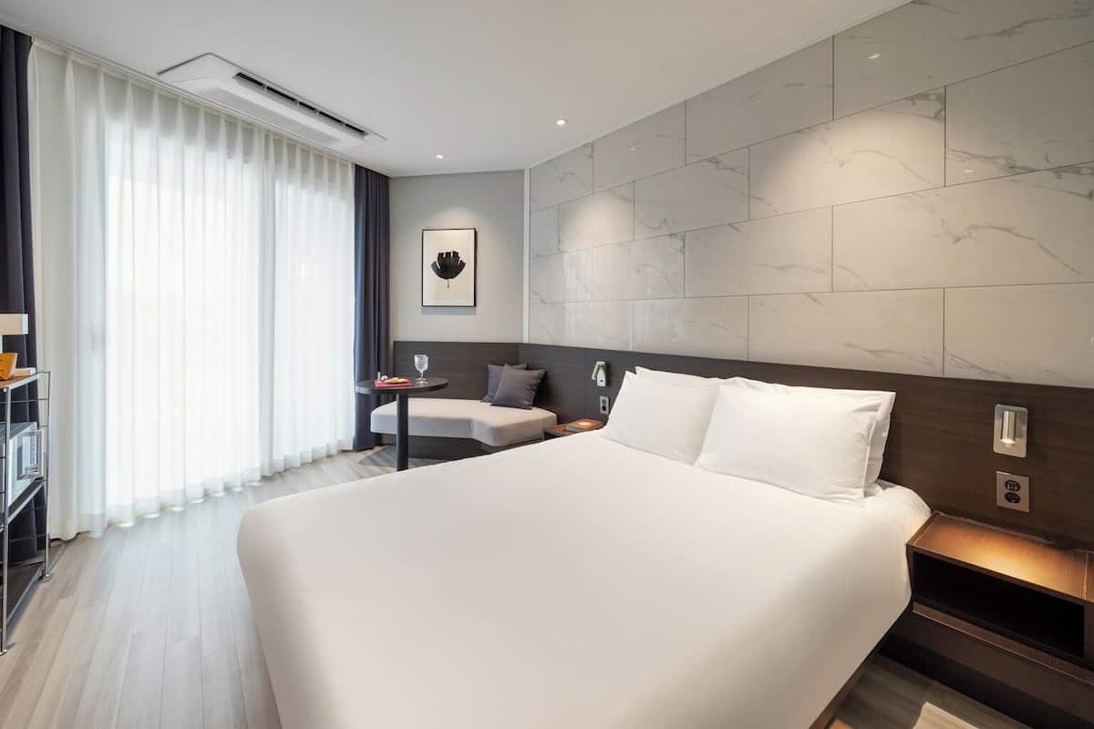 Studio Partial Ocean | Premium bedding, desk, laptop workspace, blackout curtains