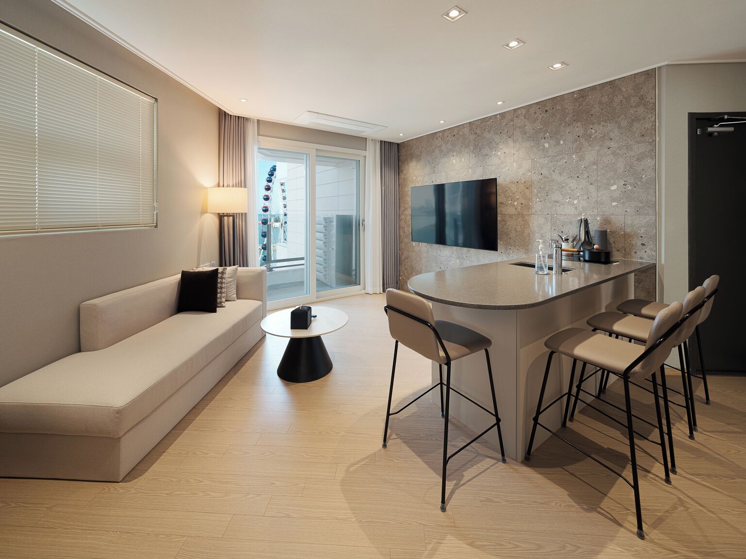 A modern living room with a sofa, a coffee table, and a bar area with stools.