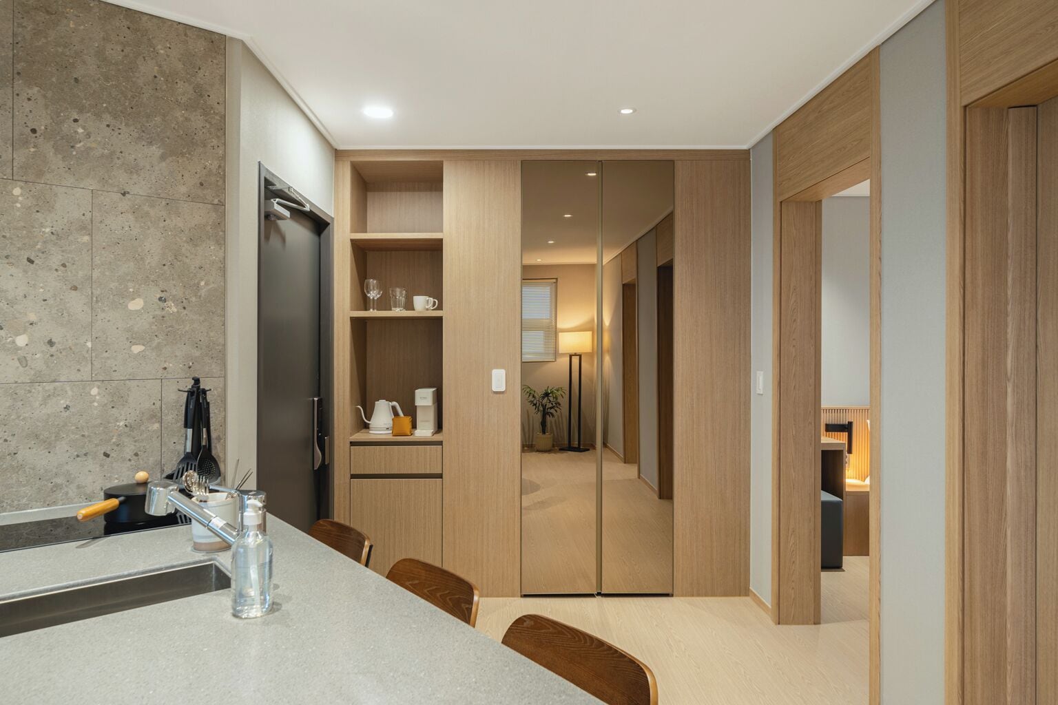Una cocina moderna con encimera de granito, armarios de madera y horno empotrado.